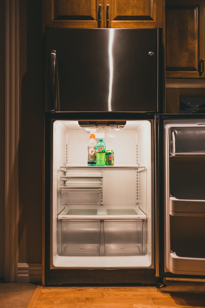 A vertically shot open refrigerator displaying Gatorade and Mountain Dew indoors.